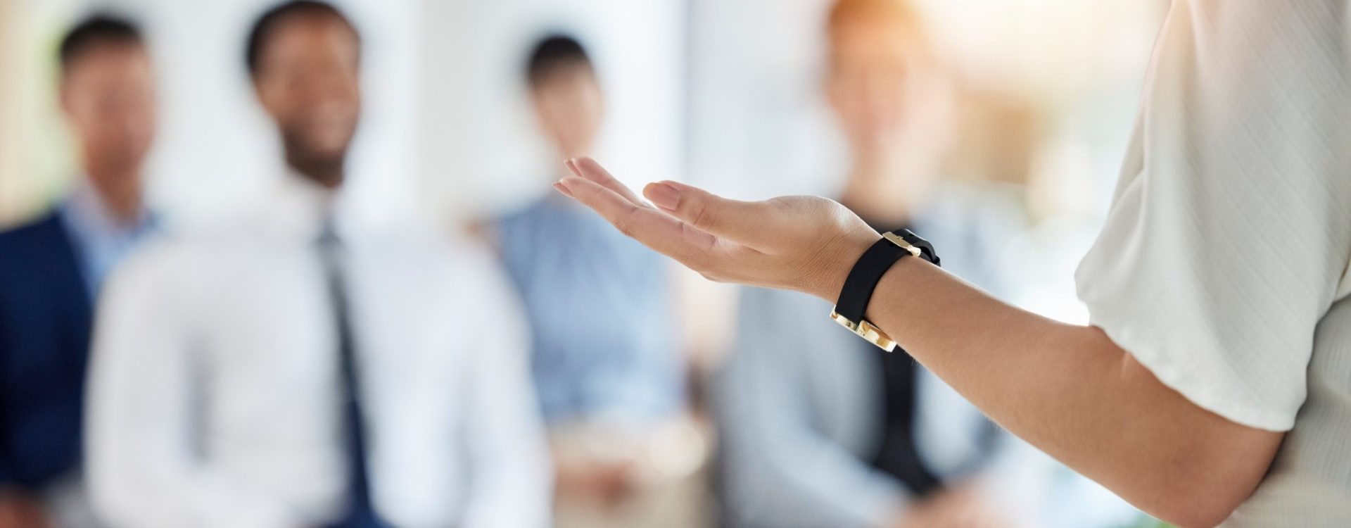 Leadership, presentation and hands of a manager in a conference for a meeting or training workshop. Coaching, staff and a speaker with a speech, talking and standing with employees for a seminar.