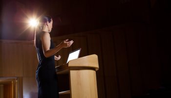 Female business executive giving a speech at conference center