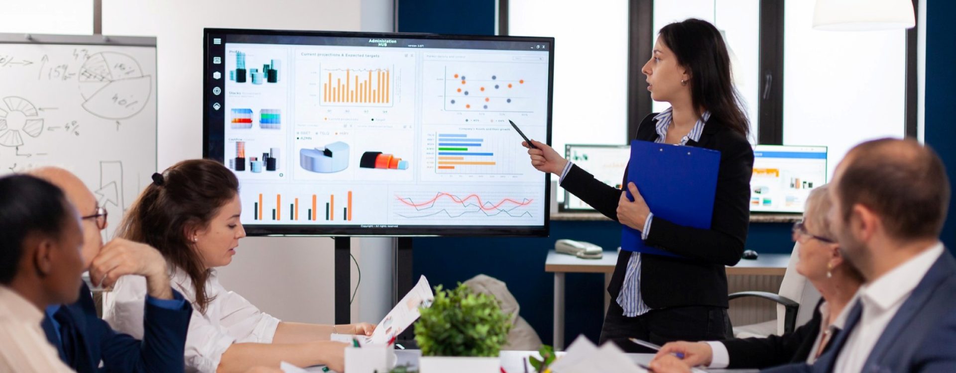 young-team-leader-big-corporation-briefing-coworkers-pointing-graph-meeting-corporate-staff (Large)